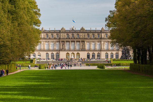 Eine Frontaufnahme vom Schloss Herrenchiemsee an einem besucherreichen Tag