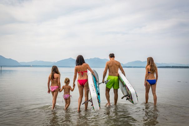 Familie am Chiemsee auf dem Weg zum Stand-Up-Paddling